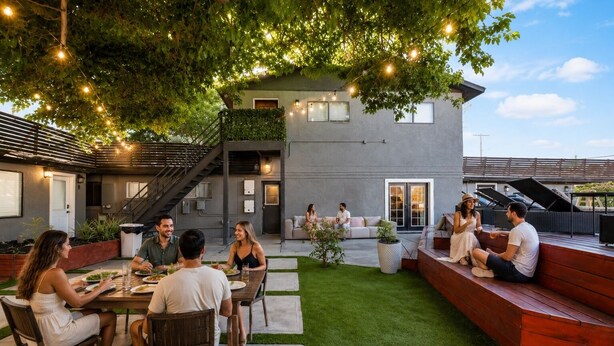 A modern outdoor dining area with a staircase, a covered seating area, and string lights. - Spacious 9-bedroom house in Las Vegas 15 min to The Strip! (Las Vegas)