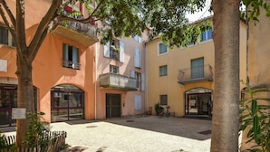 Un cortile con edifici, una bicicletta e un cartello con la scritta 'Guichet'.