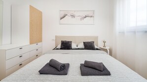 A modern bedroom with a bed, two pillows, a bedside table, a nightstand, a mirror, and a painting on the wall. - Beautiful home in Maslenica with WiFi (Maslenica)
