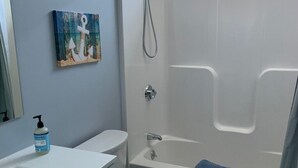 Une salle de bain avec une baignoire blanche, des toilettes et un lavabo.