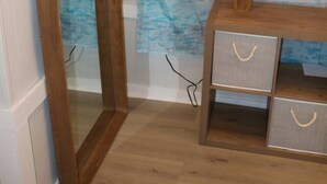 A room with a wooden arched mirror, a wooden dresser with drawers, and a wall with a painted seascape. - Seaside Social - Steps to Wally's, Goat, L Street (Hampton)