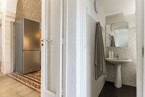 Een badkamer met een wastafel, spiegel en handdoekhouder.