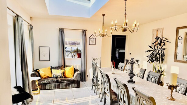 A dining area with a long table, chairs, and a chandelier. - Stunning cotswold, period country house, hot tub, great for extended family (Gloucestershire)