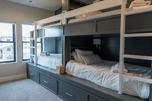 A bunk bed room with a view of buildings outside.