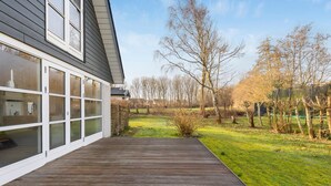A modern house with a wooden deck and large glass windows. - Cozy home in Farsø with WiFi (Farsø)