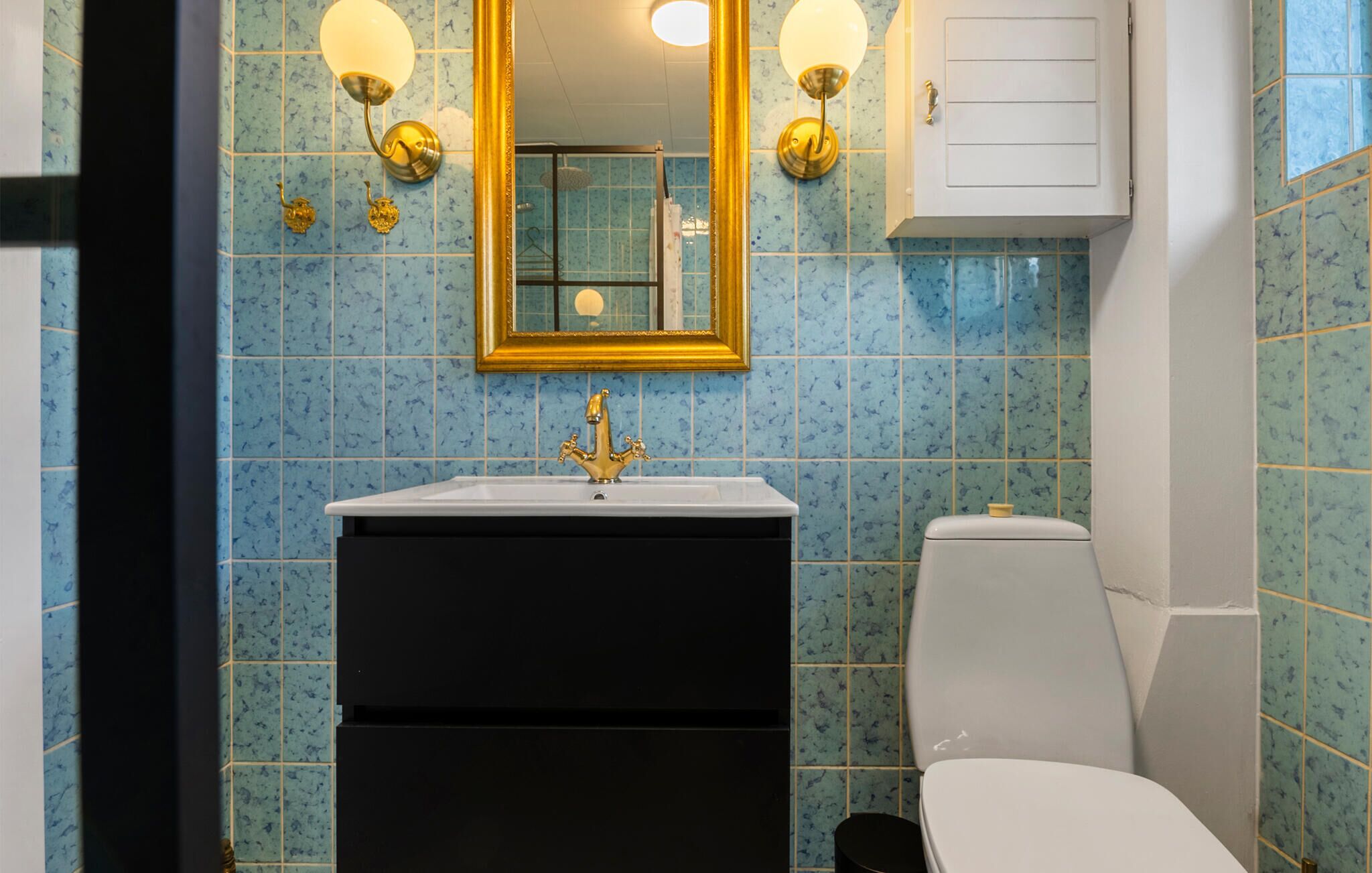 A bathroom with a sink, mirror, and toilet.