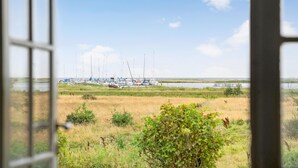 A view through a window of a marina with boats docked and a grassy area in the foreground.