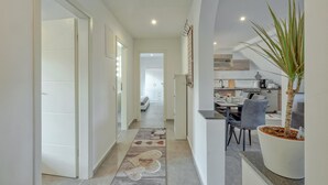 Ein modernes Interieur mit einer Diele, die in einen Essbereich und eine Küche führt.