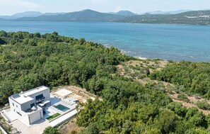 Enjoy panoramic views of a serene lake and distant mountains from this villa's hillside location.