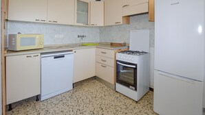 A compact kitchen with a microwave, dishwasher, stove, and refrigerator. - Lovely apartment in Calvi with WiFi (Calvi)