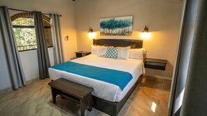 A neatly arranged bedroom with a bed, bedside tables, a bench, and a painting on the wall. - Rancho Maria Teresa (Valle de Guadalupe)
