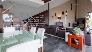 A modern living room with a glass dining table, leather sofas, a bookshelf, and a TV. - Ref. 494261 (Motril)