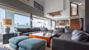 A modern living room with a sectional sofa, a coffee table, and a large window offering a view of the outdoors. - Ref. 494261 (Motril)