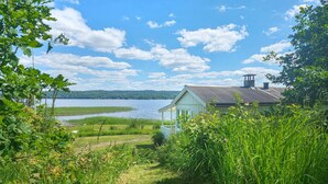 Un chalet au bord du lac, offrant une vue sur le lac et les collines lointaines.