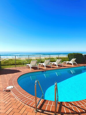 Una piscina con vistas a la playa y al océano.