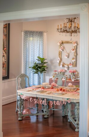 Enjoy a romantic meal at this beautifully set dining area with a vintage-style table, elegant centerpiece, and a charming potted plant.