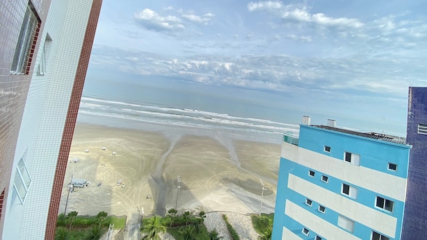 Een uitzicht op een strand met een gebouw op de voorgrond.