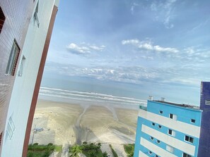 Una spiaggia con un edificio sullo sfondo.