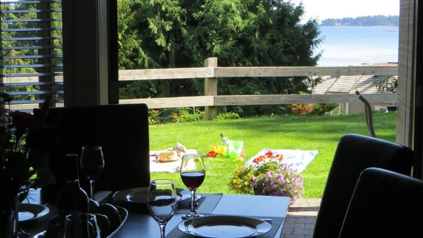 An outdoor dining area with a view of a lake and a wooden fence.