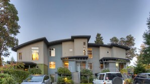 A two-story building with a curved roof, a covered front porch, and a gravel driveway.