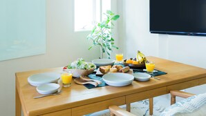 A breakfast table with plates, bowls, cutlery, and a banana. - Kago  by Tokyo Shukuba Hotel (Tokyo)