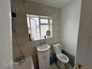 Ein Badezimmer mit Toilette, Waschbecken und Dusche.