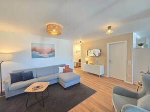 Un salon moderne avec un canapé, une table basse et un tableau accroché au mur.