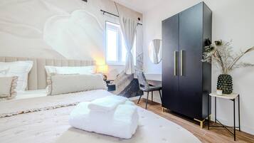 Un dormitorio moderno con una cama grande, un armario, un escritorio y un espejo decorativo.