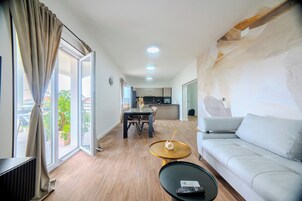 Apartment, 2 Bedrooms, Sea View | Living area | 65-inch Smart TV with digital channels, heated floors