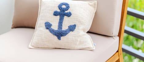 Ein Stuhl mit Kissen, verziert mit einem blauen Anker-Motiv.