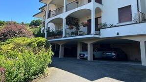 A two-story building with a covered parking area and a balcony with railings. - Marenco apartment in Stresa with lake view (Stresa)