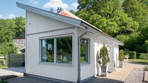 Een klein, laag gebouw met grote ramen en een schuin dak.