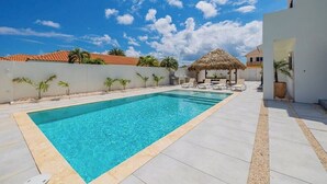 Une piscine rectangulaire à l’eau d’un bleu limpide, entourée d’une terrasse carrelée.