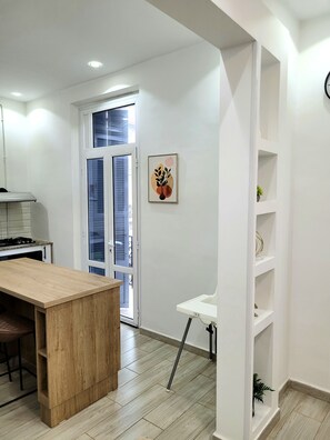 A modern kitchen with a wooden island, a white countertop, and a built-in stove.