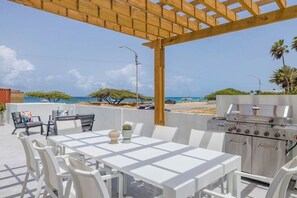 Relax on the patio with a grill and seating area overlooking the beach.