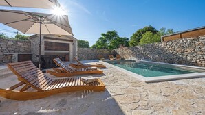 A pool area with lounge chairs and a barbecue grill. - Cozy home in Mirlovic Zagora (Mirlovic Zagora)