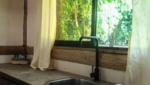 Eine Küche mit Spüle, Holz Arbeitsplatte und einem Fenster mit Vorhängen.