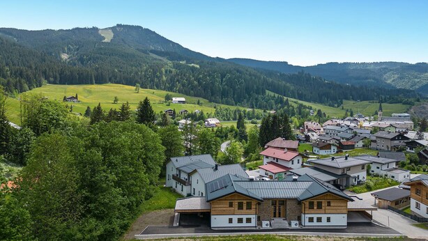 A residential area with houses, a church, and a mountain backdrop. - Pet friendly apartment (Rußbach am Pass Gschütt)