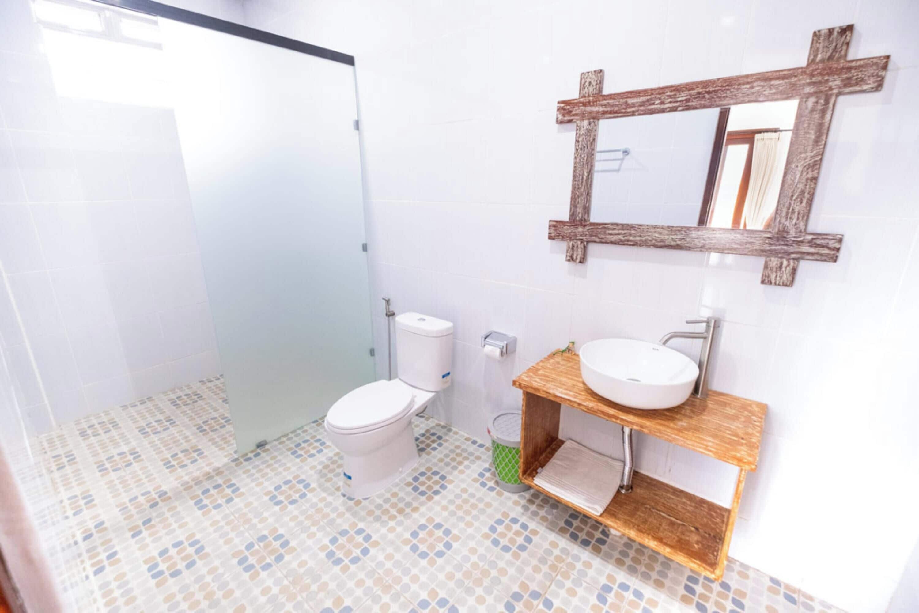 Une salle de bain avec des toilettes, un lavabo et un miroir.