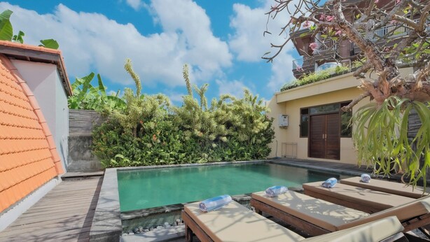 A pool area with lounge chairs and a wooden deck. - Sandat Bali Villa (Canggu)