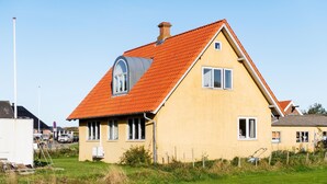 A yellow house with a red roof, a large window, and a small balcony. - Beautiful apartment in Ribe with WiFi (Ribe)