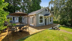A house with a deck, a patio with outdoor furniture, and a large umbrella. - Perch - Ballard Delight: Great Ballard location! Spacious House w/parking (Seattle)