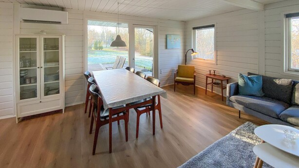 Une pièce spacieuse comprenant une table à manger, des chaises, un canapé et un meuble.