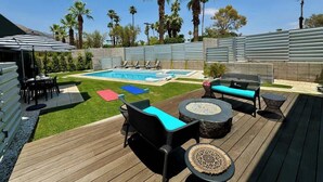 A backyard with a pool, outdoor furniture, and palm trees. - New! Audrey's Luxury Retreat - Walk Downtown (Palm Springs)