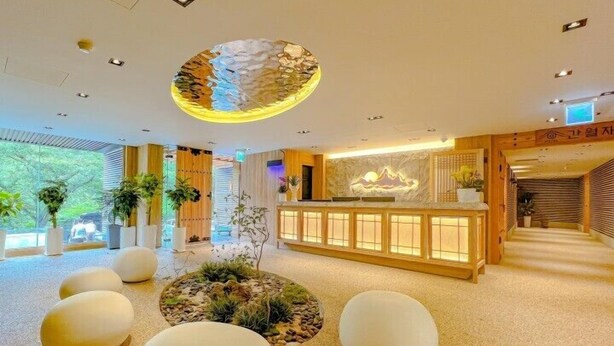 A modern hotel lobby with a reception desk, seating areas, and a decorative ceiling. - HOTEL KANWOLGE (Ulsan)