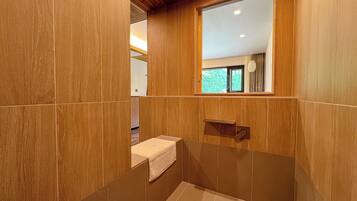 A bathroom with wooden paneling, a window, a towel, and a sink.