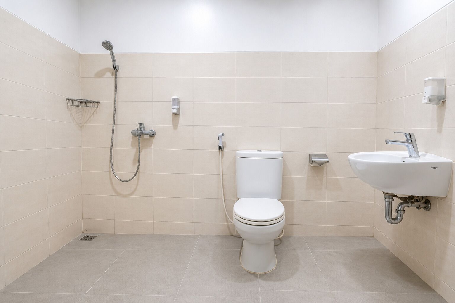 Uma casa de banho com sanita, chuveiro e lavatório.