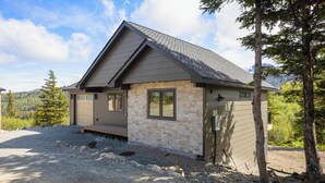 A small, single-story house with a sloped roof and a stone facade. - Cozy Guest House In The Chugach Mountains  (Anchorage)