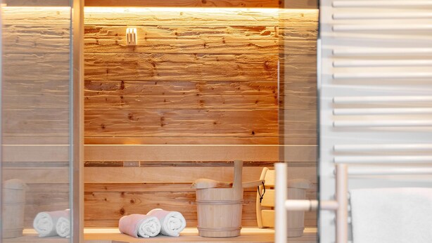 Uma sauna com bancos de madeira e um assento de apoio.