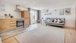 Un appartement moderne comprenant une cuisine, un coin repas et un salon avec un canapé.